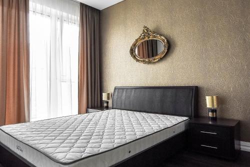 een slaapkamer met een bed met een spiegel aan de muur bij Four Luxury flats in Kaunas