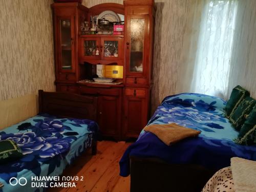 a bedroom with a bed and a cupboard and a bed and a bedskirts at Nora's guesthouse in Zhabeshi