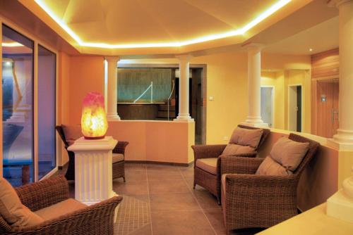 a living room with chairs and a table with a lamp at Landhotel Hauer in Pleisweiler-Oberhofen