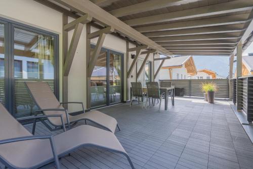 a porch with chairs and tables on a house at Appartement Schöpf in Längenfeld