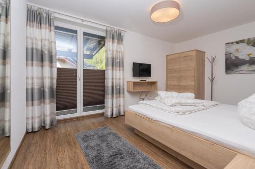 1 dormitorio con cama y ventana grande en Appartement Schöpf, en Längenfeld