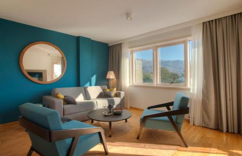 a living room with a couch and chairs and a mirror at Fontana Hotel & Gastronomy in Budva