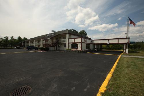 a building with a flag in a parking lot at Days Inn by Wyndham Queensbury/Lake George in Queensbury