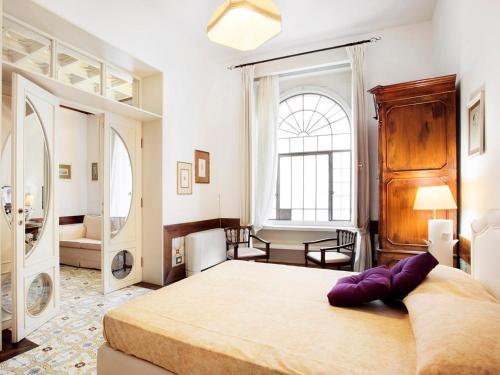ein Schlafzimmer mit einem großen Bett und einem großen Fenster in der Unterkunft Foro Romano in Rom