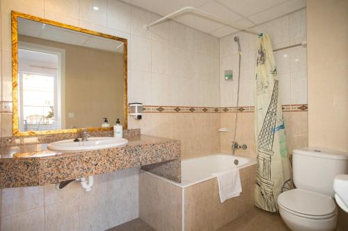a bathroom with a sink and a toilet and a tub at Hotel Villa Barbara in Can Picafort