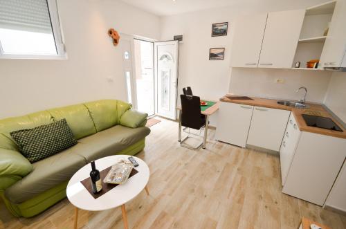 a living room with a green couch and a table at Apartment The Sea Coast in Kotor