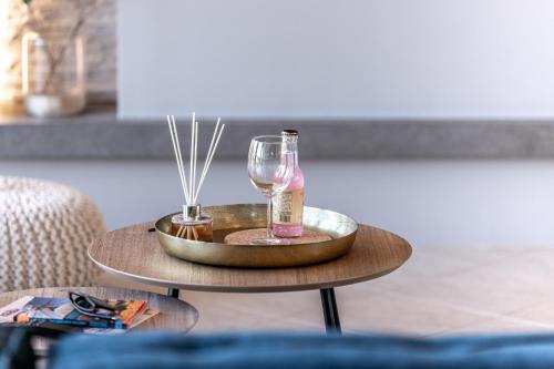 a table with a wine glass and a bottle on it at Gregory’s Loft in Ayia anna