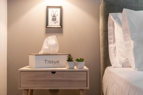 a table with a tissue box on it next to a bed at Gregory’s Loft in Ayia anna