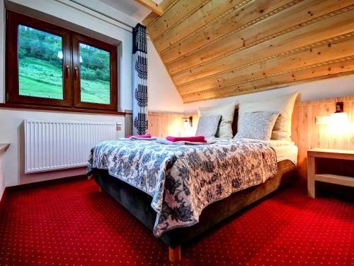 ポロニンにあるDomki Skalnicaの木製の天井のベッドルーム1室(大型ベッド1台付)