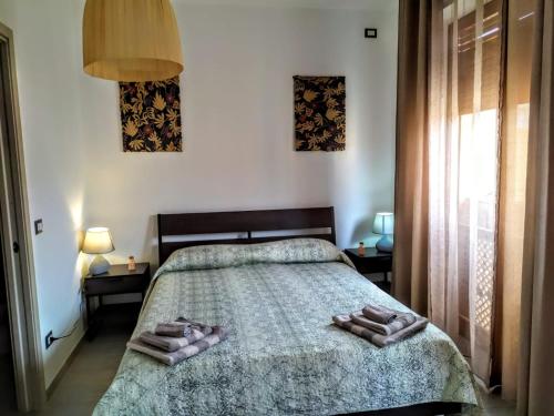 1 dormitorio con 1 cama con 2 toallas en B&B Libellula, en Iglesias