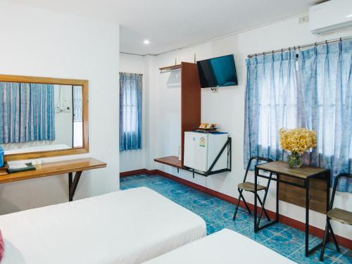 a hotel room with two beds and a television at Rendezvous Oldtown Chiangmai in Chiang Mai