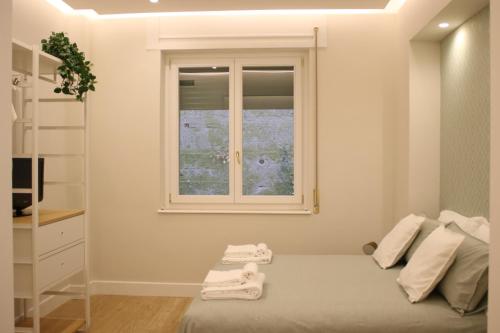 sypialnia z oknem i łóżkiem z ręcznikami w obiekcie La Casa nel Parco w mieście Napoli