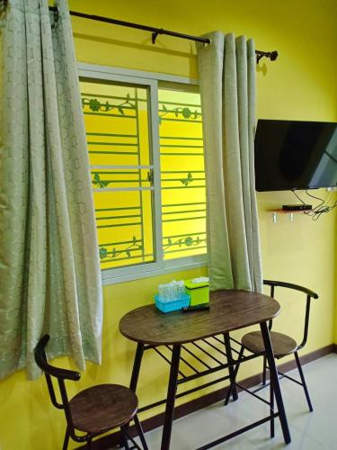 a table and two chairs in front of a window at Siri Guesthouse in Phra Nakhon Si Ayutthaya