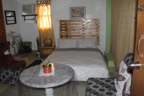a bedroom with a bed and a table in it at Maraño's Home in Legazpi
