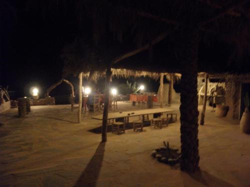 a pavilion with a table and benches at night at Maison Boutchrafine in Erfoud