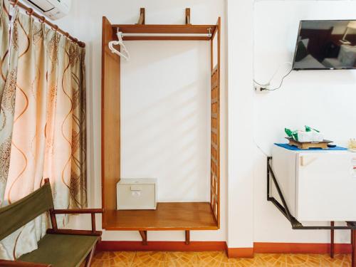 a mirror in a room with a chair and a tv at Rendezvous Oldtown Chiangmai in Chiang Mai