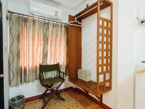 a room with a chair and a window at Rendezvous Oldtown Chiangmai in Chiang Mai