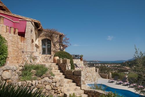 a stone house with a staircase leading to a swimming pool at SundanceMallorca in Port de Pollensa