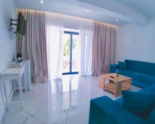 a living room with a blue couch and a table at Limnionas Bay Village Hotel in Marathokampos