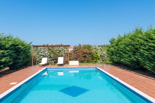 a large swimming pool with a brick deck at Navarone Villas in Petrokhorion