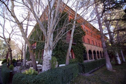 a red building with trees in front of it at Hotel Xabier in Javier