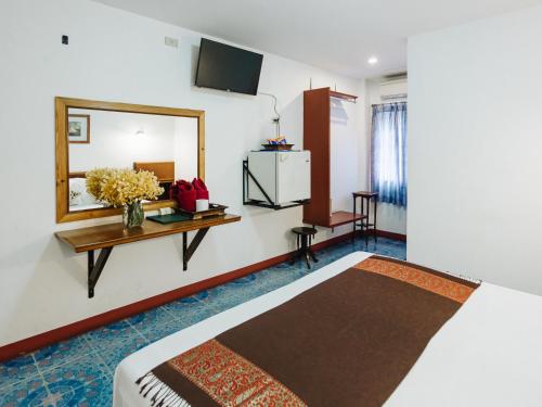 a hotel room with a bed and a mirror at Rendezvous Oldtown Chiangmai in Chiang Mai