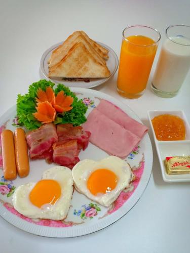 a plate of breakfast food with eggs bacon and toast at Siri Guesthouse in Phra Nakhon Si Ayutthaya