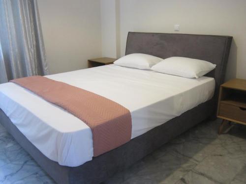 a bedroom with a large bed with white sheets and pillows at Blue Yard Apartments in Kalamata