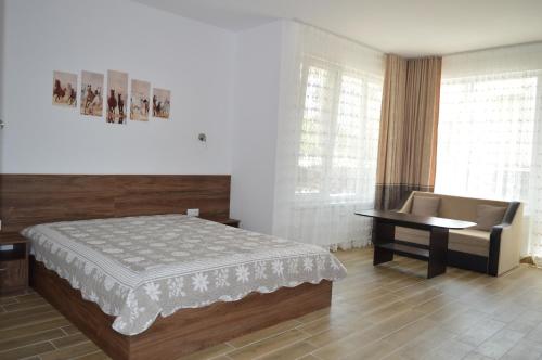 a bedroom with a bed and a table and a desk at SummerHouse Lozenets in Lozenets