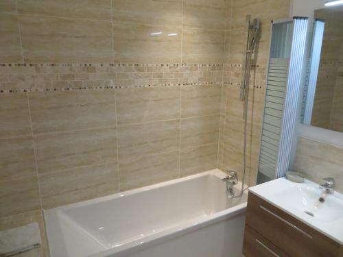 een badkamer met een bad en een wastafel bij Domaine de Christin Studios-Hôtel in Junas
