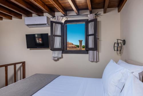 een slaapkamer met een bed en een raam met uitzicht bij Zacosta Villa Hotel in Rhodos-stad