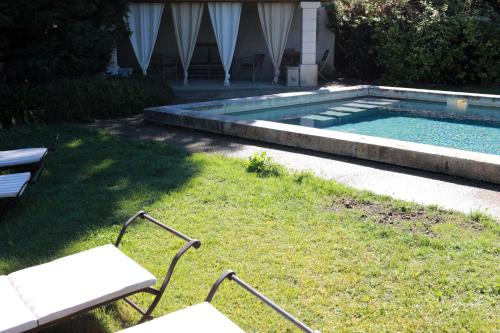 a swimming pool in a yard with a bench next to it at Justin de Provence in Orange