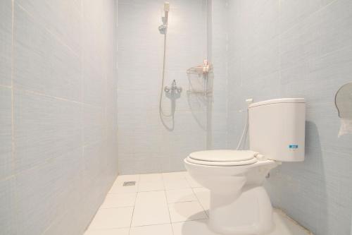 een badkamer met een toilet en een douche bij OYO 1097 Appartel Cempaka in Pontianak