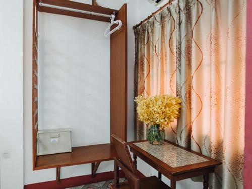 a vase of flowers on a table in a room at Rendezvous Oldtown Chiangmai in Chiang Mai