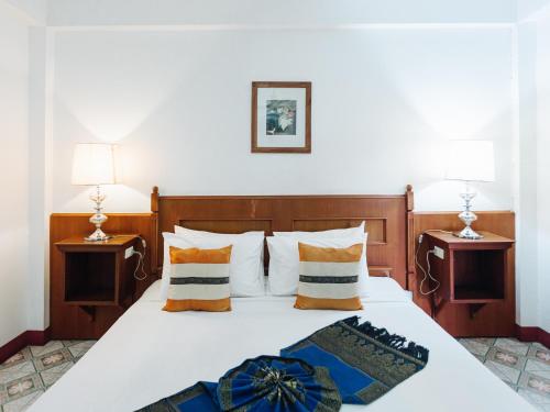 a bedroom with a large bed with two night stands at Rendezvous Oldtown Chiangmai in Chiang Mai