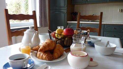 uma mesa com pequeno-almoço de croissants, café e ovos em Gite la Ville Brunet em Saint-Briac-sur-Mer