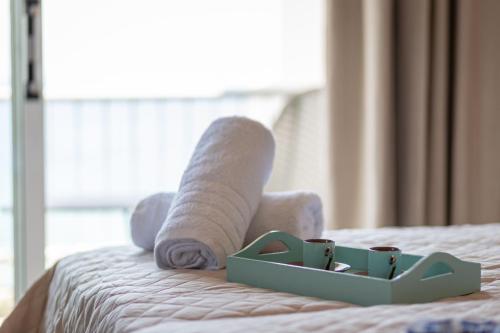 a person with socks and cups on a bed at Euphoria Blue studio apartments in Artemida