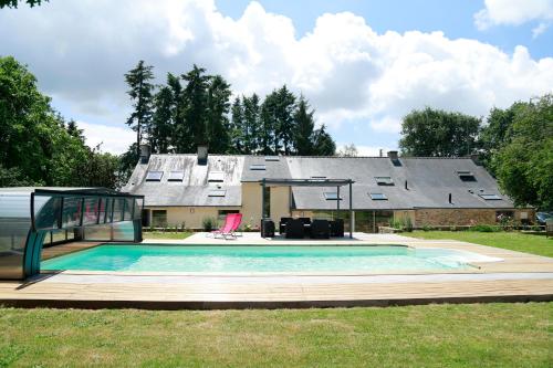 a swimming pool in front of a house at Aux Agapanthes in Pluherlin