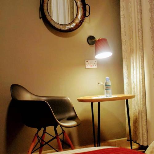 a chair and a table and a bottle of water on a table at Mahali Guesthouse, Makindye Hill in Kampala