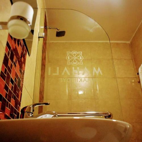 a bathroom with a sink and a sign on the wall at Mahali Guesthouse, Makindye Hill in Kampala