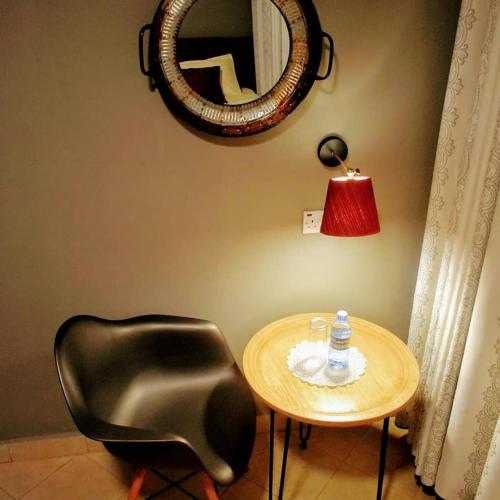 a table with a black chair and a mirror at Mahali Guesthouse, Makindye Hill in Kampala