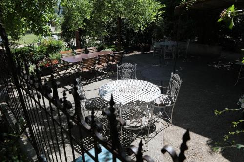 a table and chairs in a garden with a fence at Justin de Provence in Orange