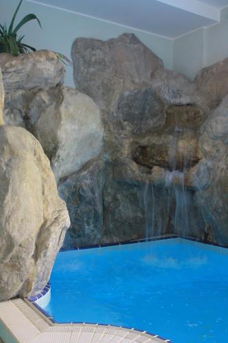 a faux rock wall with a waterfall in a swimming pool at Residence Le Vele in Cattolica