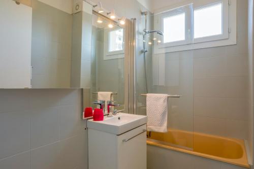 une salle de bain blanche avec un lavabo et une douche dans l'établissement Les terrasses de Toulouse Compans, à Toulouse