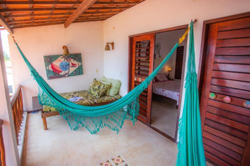a hammock in a room with a bedroom at Pousada Jangada Prea in Prea