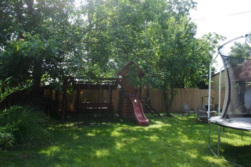 a backyard with a slide and a playground at Tessedik Vendégház in Hajdúszoboszló