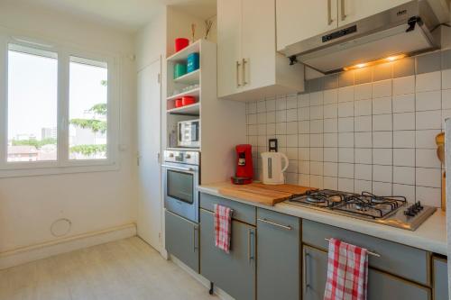 Il comprend une cuisine équipée d'une cuisinière. four supérieur à côté d'une fenêtre dans l'établissement Les terrasses de Toulouse Compans, à Toulouse