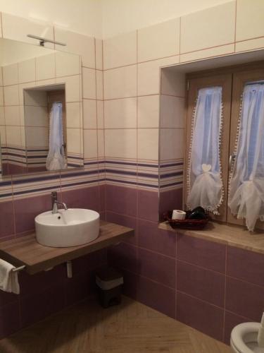 une salle de bain avec un lavabo et un miroir dans l'établissement La Villetta Apartments, à Castel Gandolfo