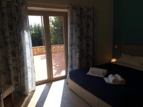 une chambre avec un lit et une porte coulissante en verre dans l'établissement La Villetta Apartments, à Castel Gandolfo