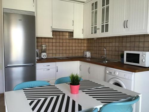 una cucina con un tavolo con una pianta sopra di Baja Larga a Playa de San Juan